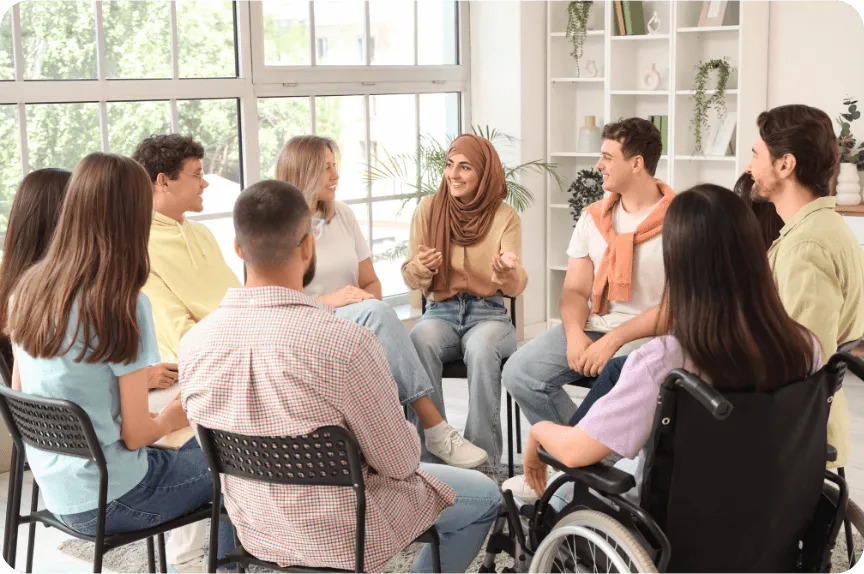 Grupo de personas sentadas en círculo compartiendo experiencias